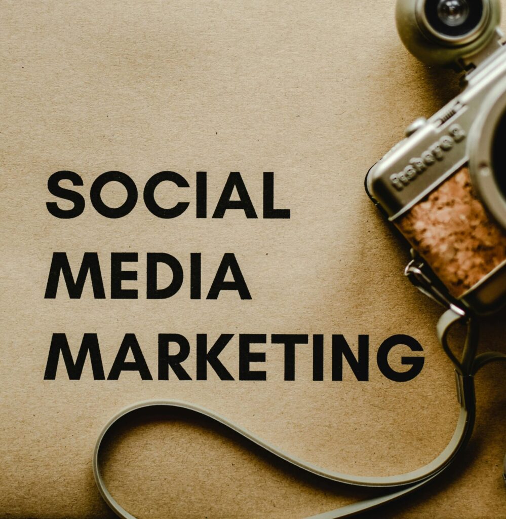 Close-up of a vintage camera next to a social media marketing concept text on a brown background.